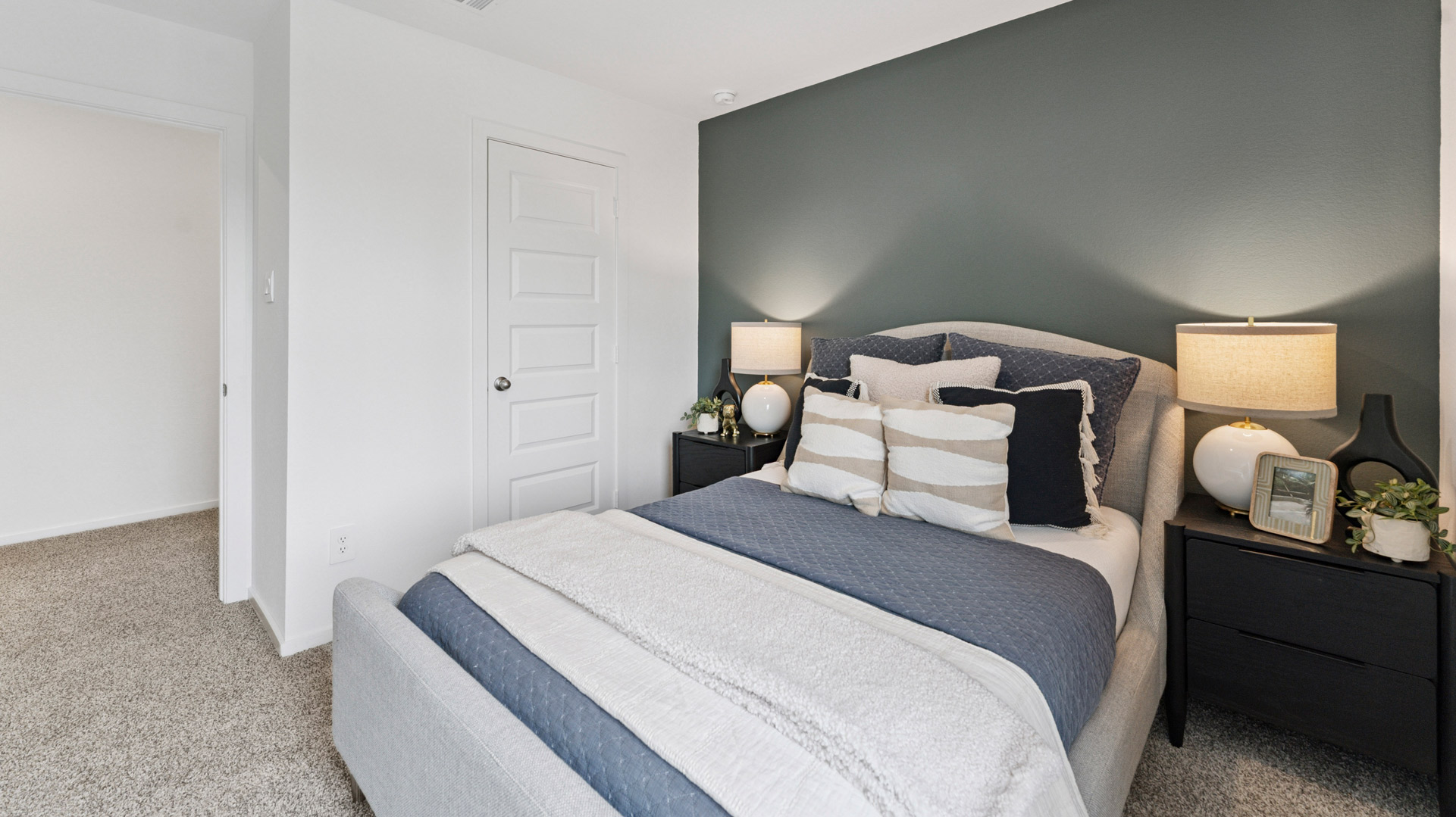 the second bedroom, located upstairs, has carpet flooring and light neutral walls