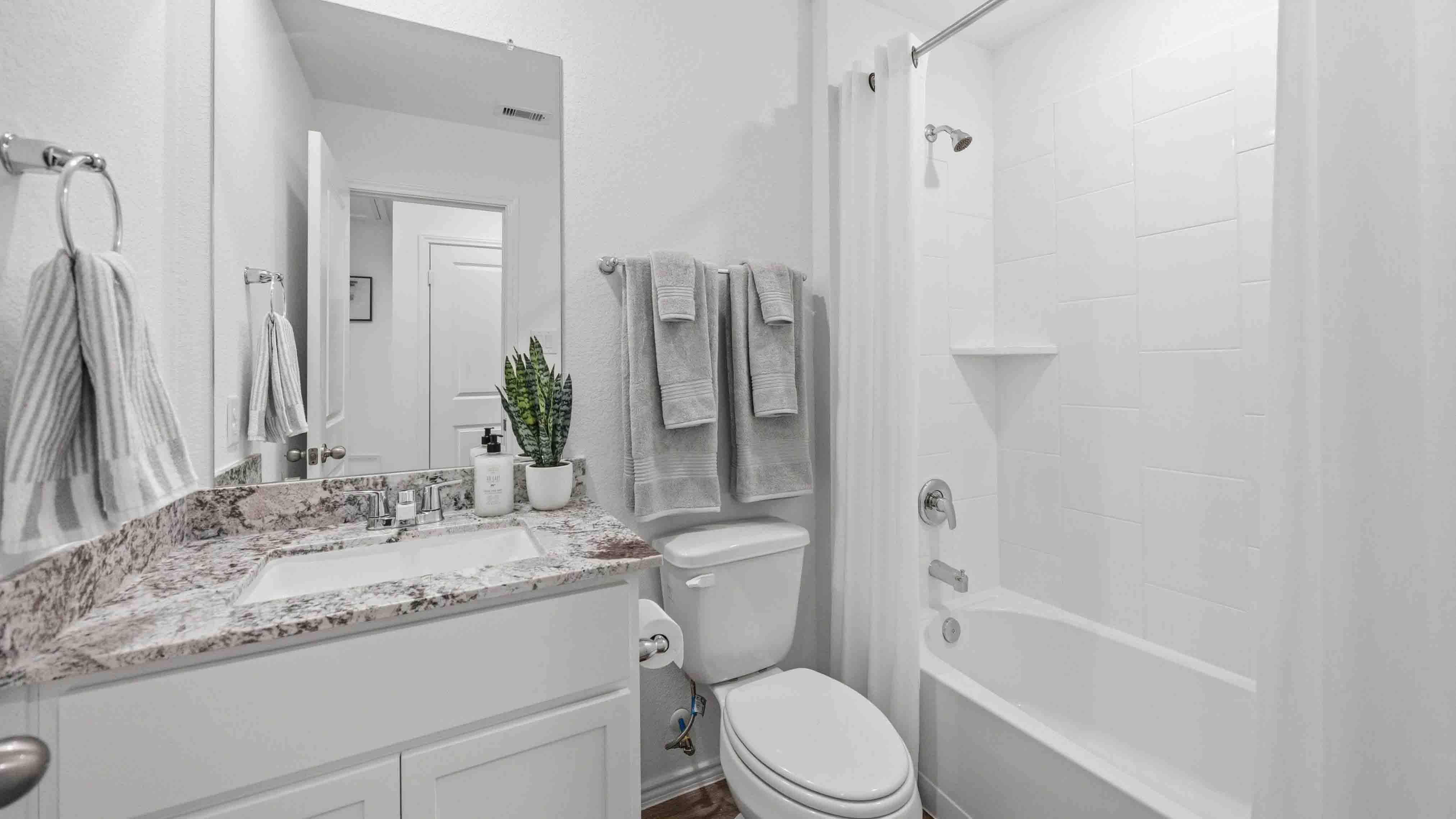 primary bathroom with a single vanity sink and a standing tub