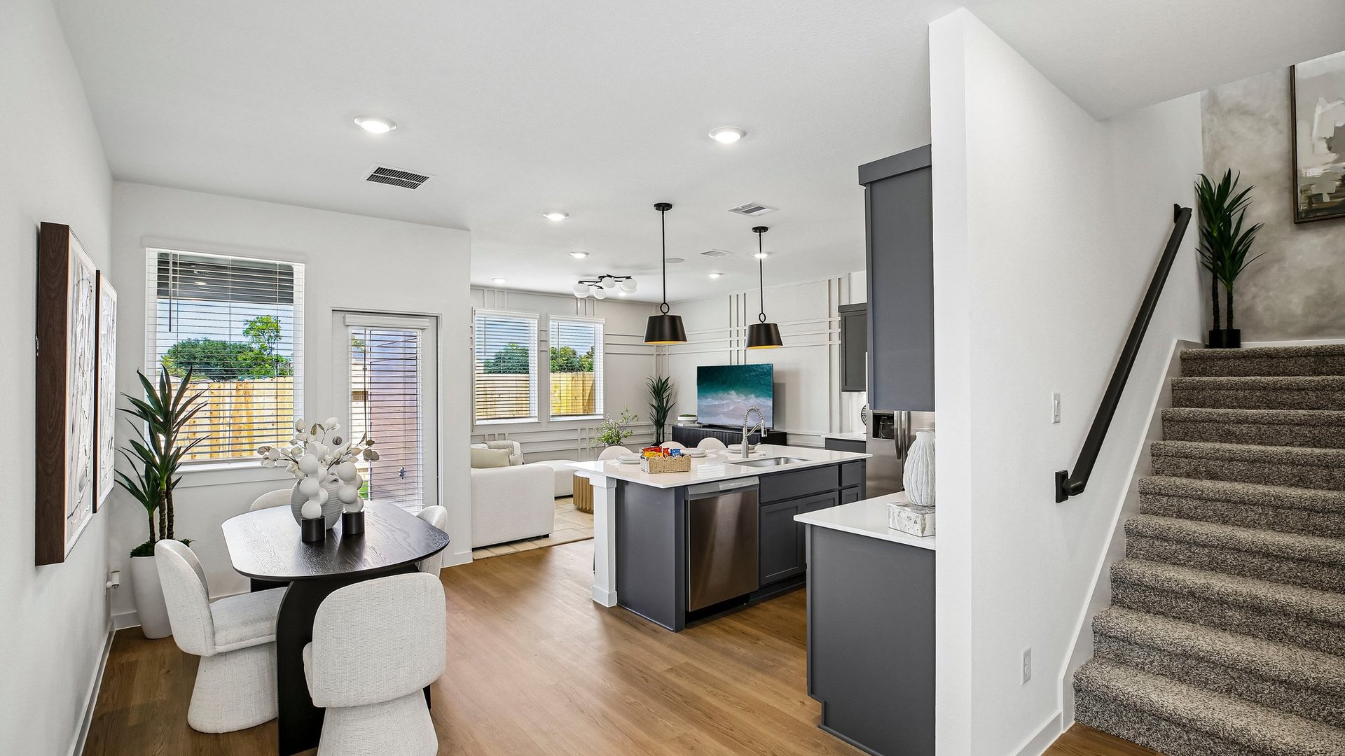 Bright kitchen showcasing quartz countertops, contemporary cabinetry, and seamless flow into the living area.