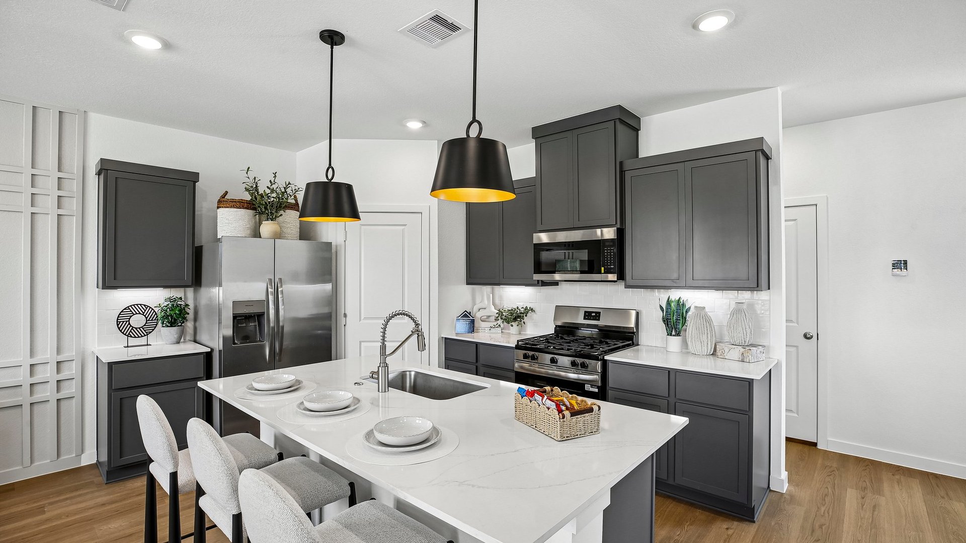 Open-concept kitchen with quartz surfaces, decorative tile backsplash, and abundant natural light.