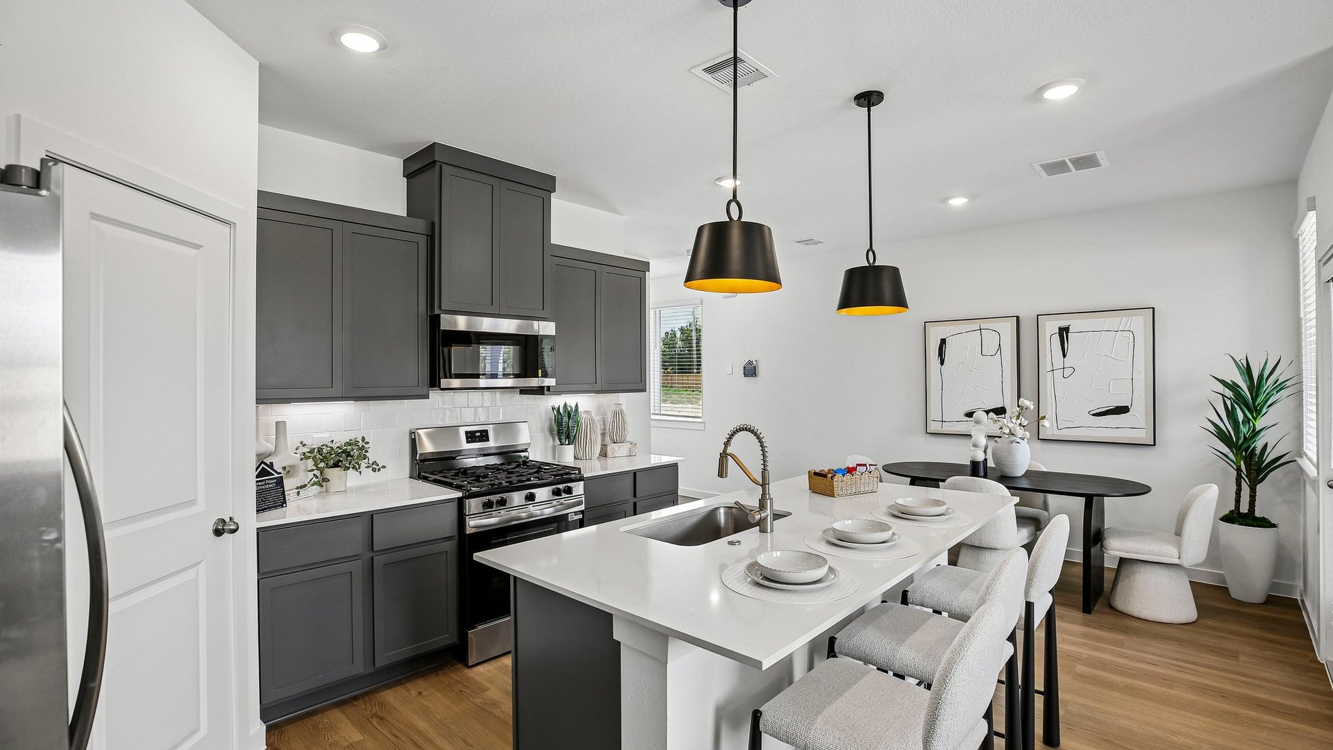 Open-concept kitchen with quartz surfaces, decorative tile backsplash, and abundant natural light.