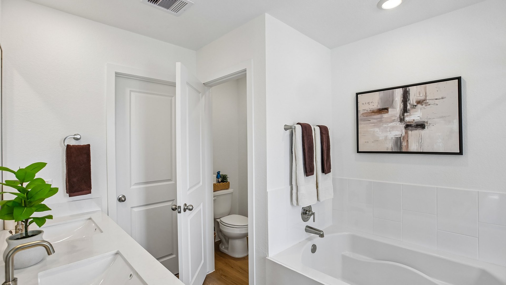 Bright bathroom retreat featuring dual sinks and a walk-in shower.