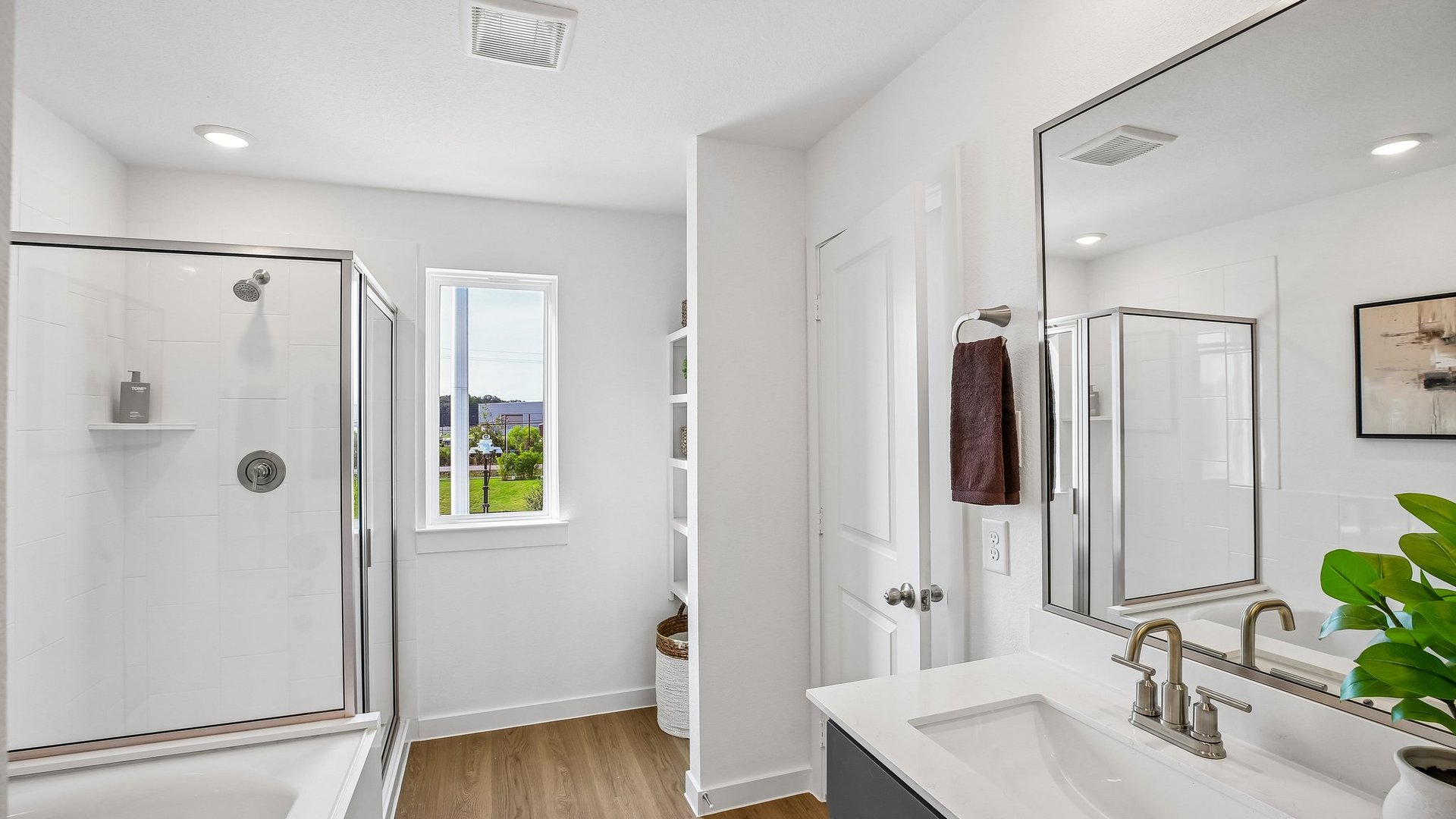 Bright bathroom retreat featuring dual sinks and a walk-in shower.