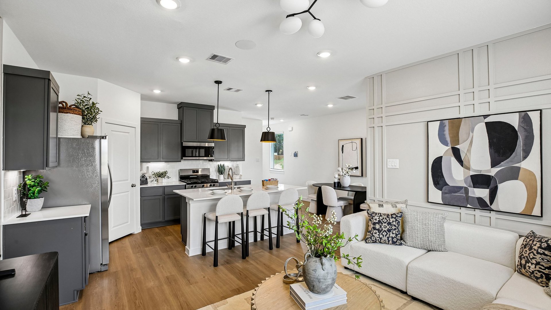 Bright kitchen showcasing quartz countertops, contemporary cabinetry, and seamless flow into the living area.
