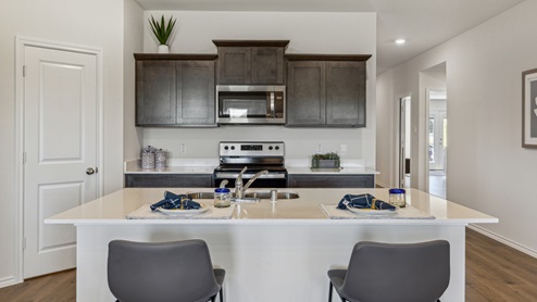 Kitchen island with brown cabinets and stainless steel appliances