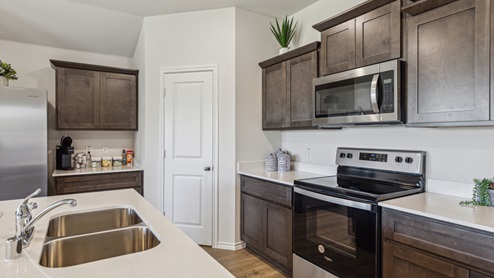 Kitchen island with brown cabinets and stainless steel appliances