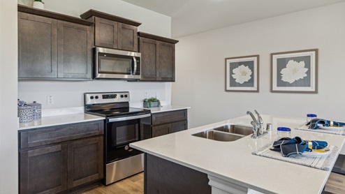 Kitchen island with brown cabinets and stainless steel appliances