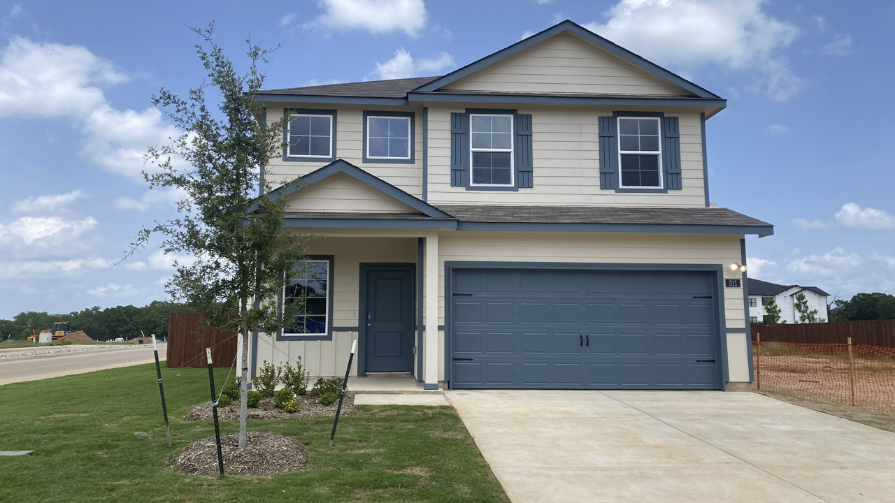 exterior of two story home with light colored siding and blue accents