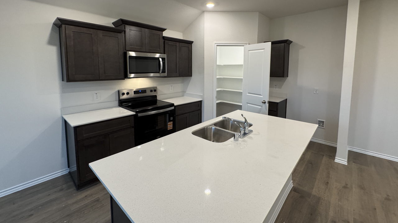 kitchen area with white counters and dark colored cabinets