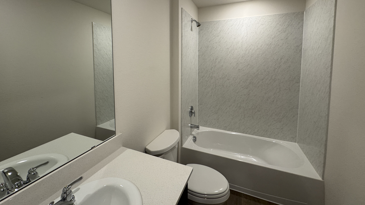 secondary bathroom with hardwood floors and white counters