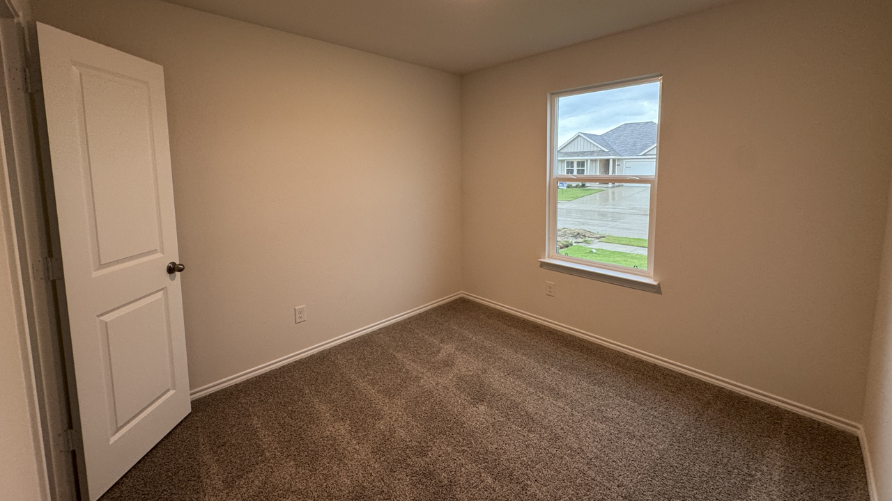 secondary bedroom with carpet and large window