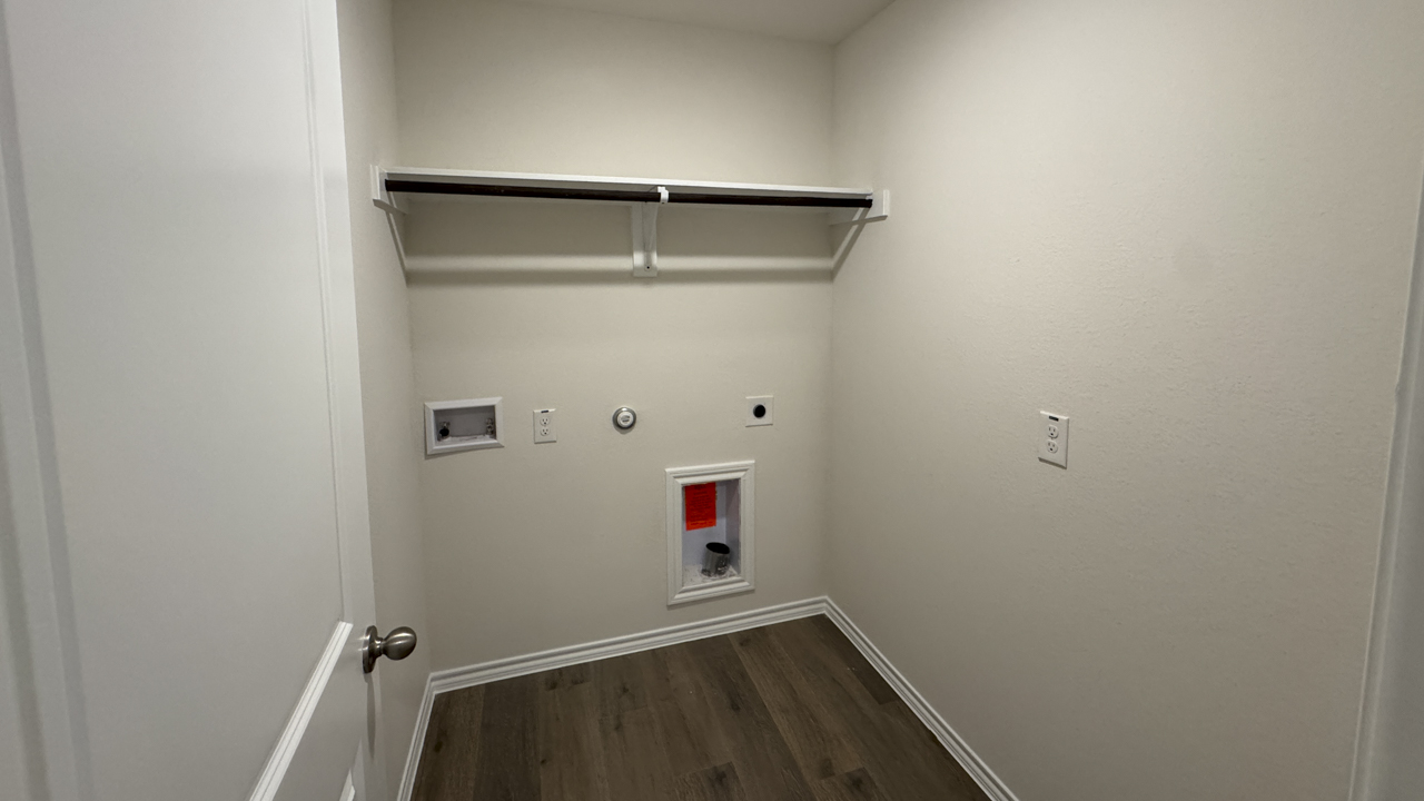 utility area for washer and dryer with hardwood floors