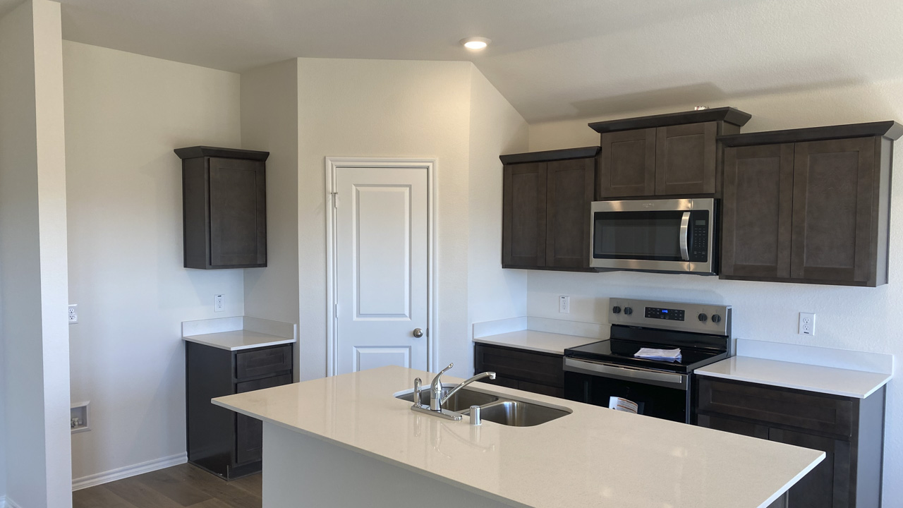 kitchen area with dark cabinets and white counters
