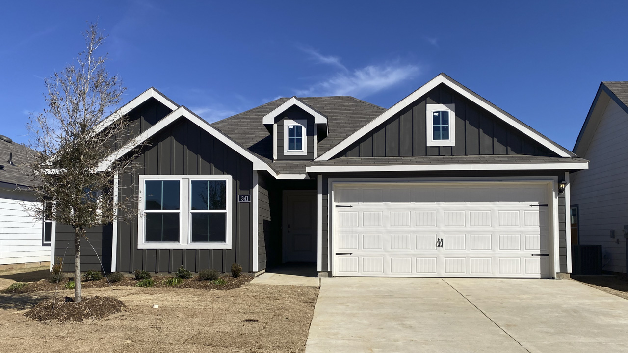 Exterior with dark colored wood white accents and garage door with large windows facing the front yard