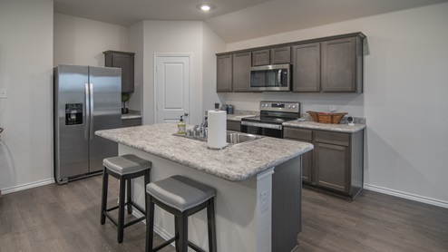 X40B kitchen area with granite countertops and dark cabinets