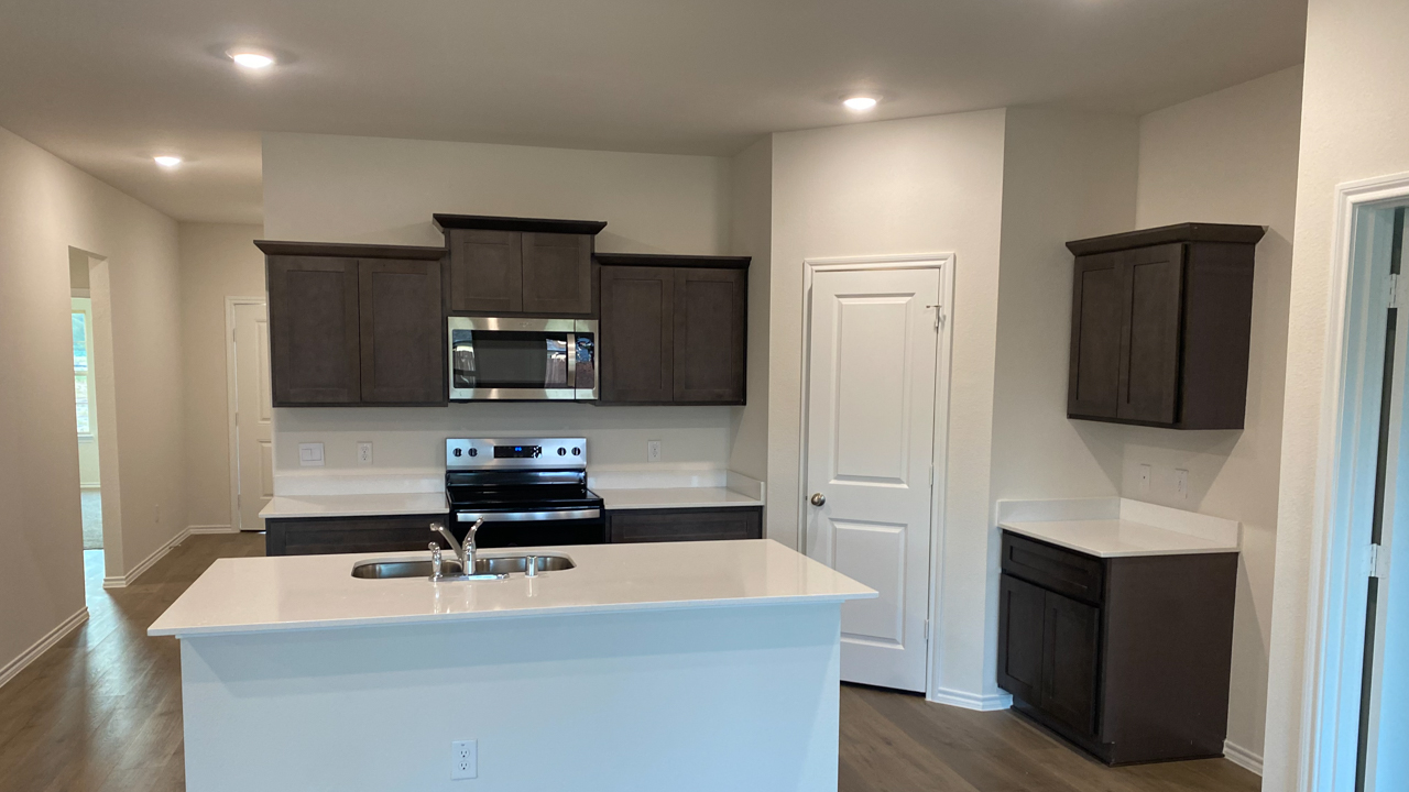kitchen area with hardwood floors dark cabinets and light colored cabinets