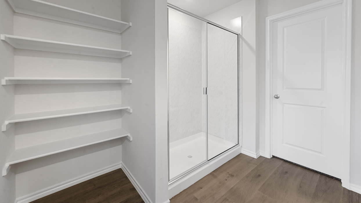 primary bathroom white storage selves and walk in shower