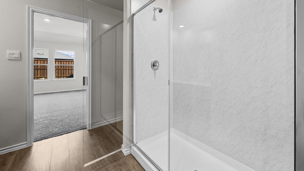 primary bathroom with walk in shower and white tiles
