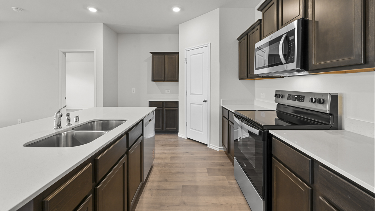 Kitchen dispalyed with white graniet countertops and dark stained cabinets