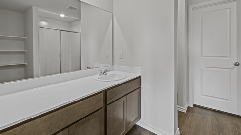 X40H primary bathroom with white counters and brown cabinets