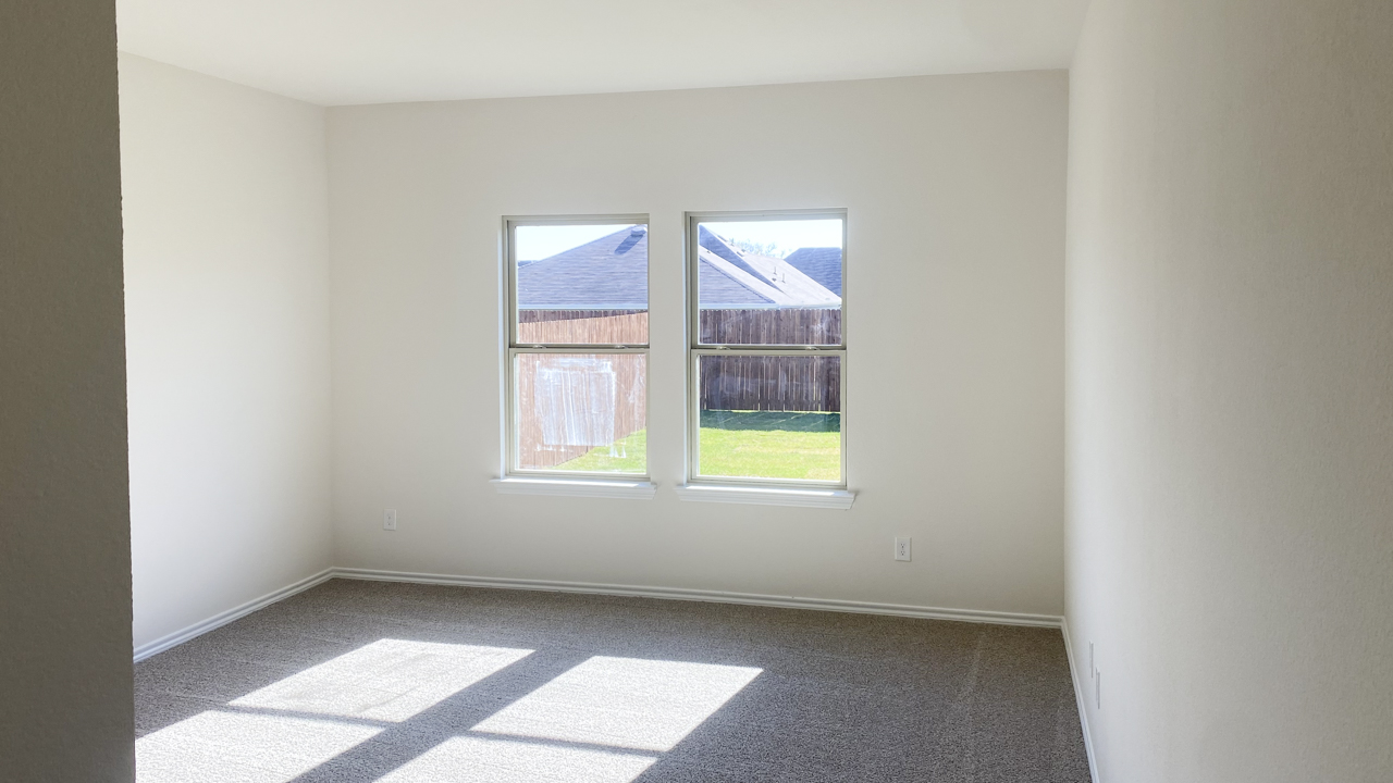 primary bedroom with carpet and large windows