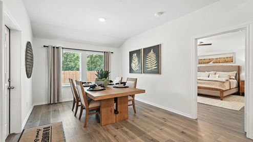 Dining area with windows for natural lighting and door for access to backyard.