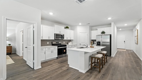 Open concept kitchen with quartz countertops and an island.