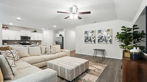 Open living room with brown flooring and white walls.