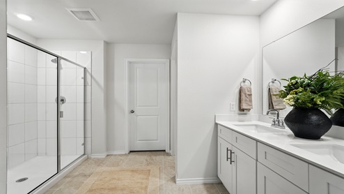 Bathroom with dual vanity sink and a spacious walk in shower.