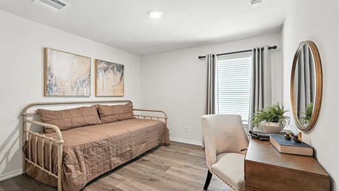 Bedroom with brown flooring and a single window.