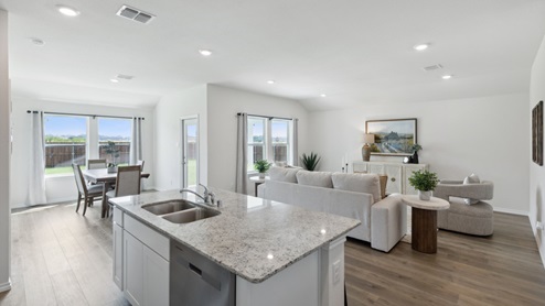 Huntsville model living room with furniture and windows from kitchen island and sink