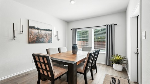 Dining area with a window and door for access to backyard.