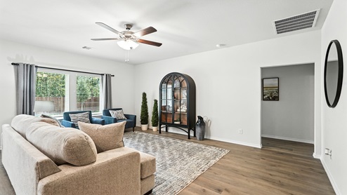 Living room with brown flooring and a large window for natural lighting.