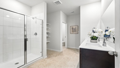 Bathroom with dual vanity sinks and a walk in shower.