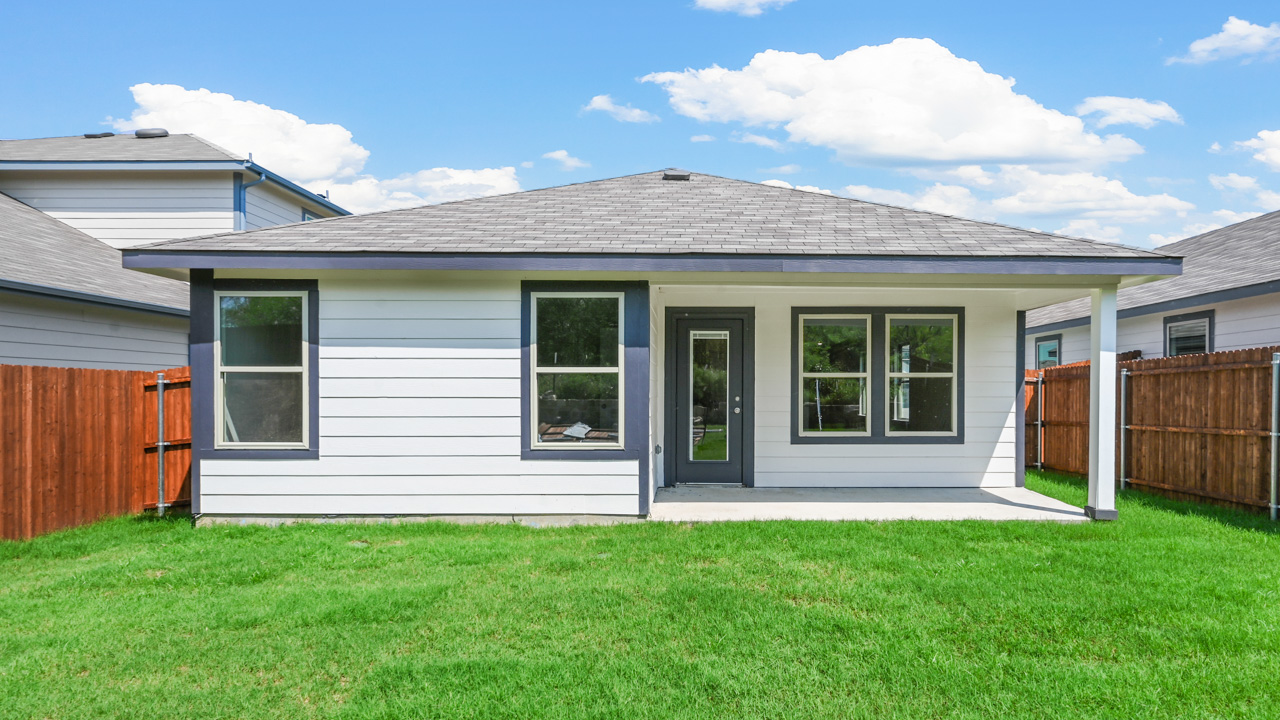 backside of one story home with siding and covered back patio