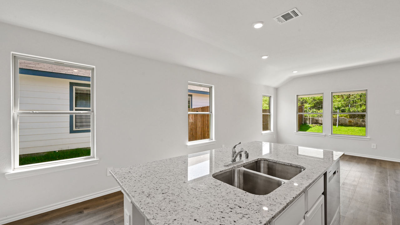kitchen overlooking hallway and living room area from the kitchen island with sink