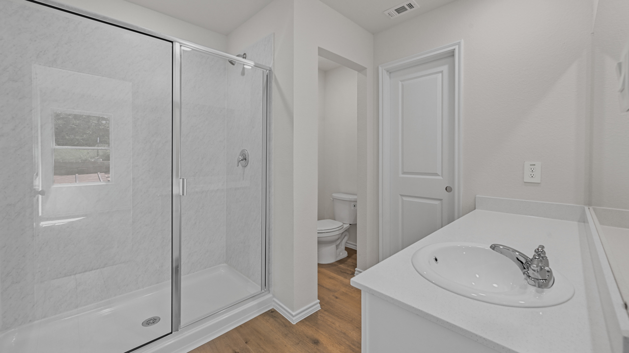 large primary bathroom with walkin shower and elongated vanity