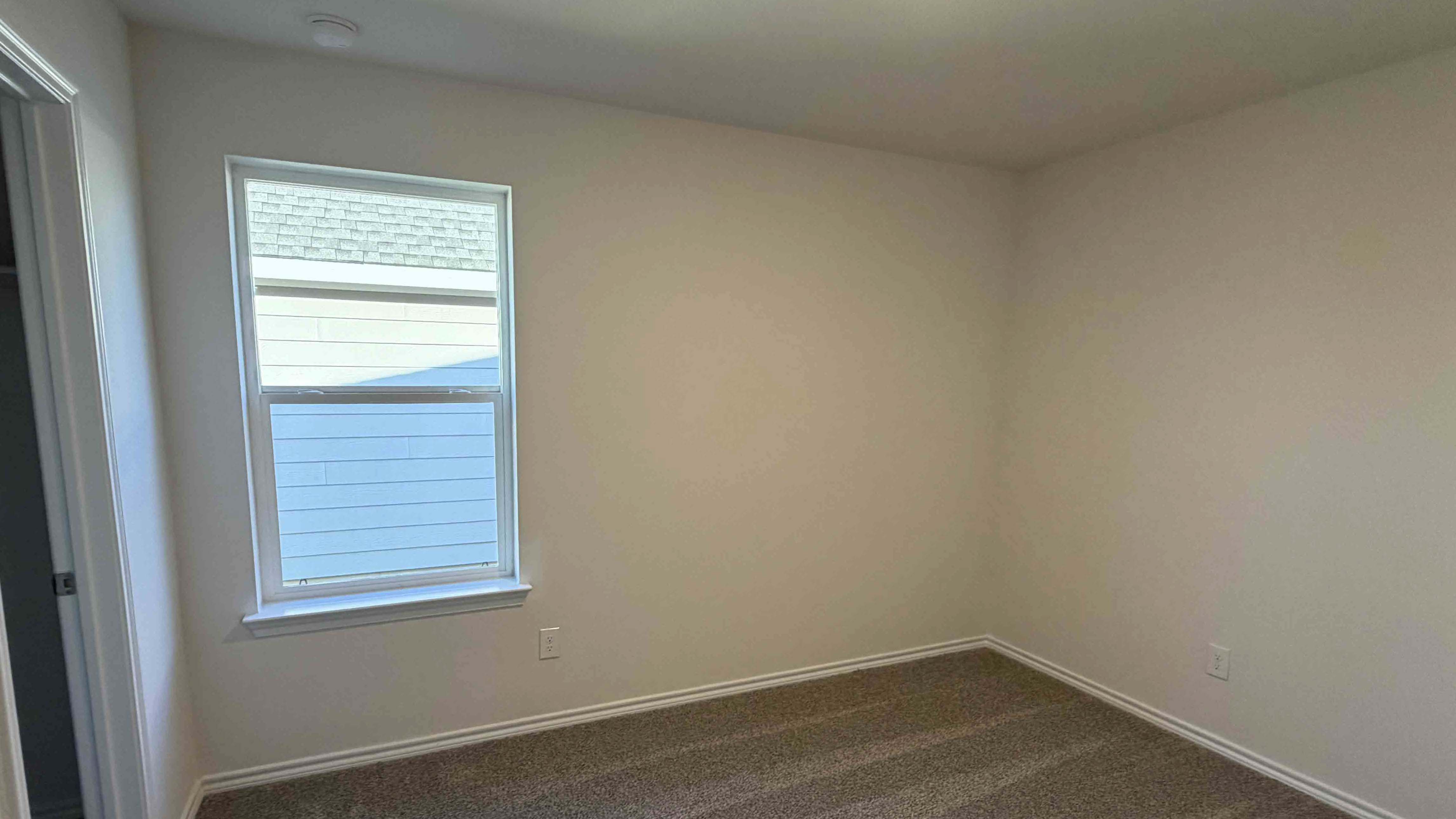 secondary bedroom with large window providing natural light