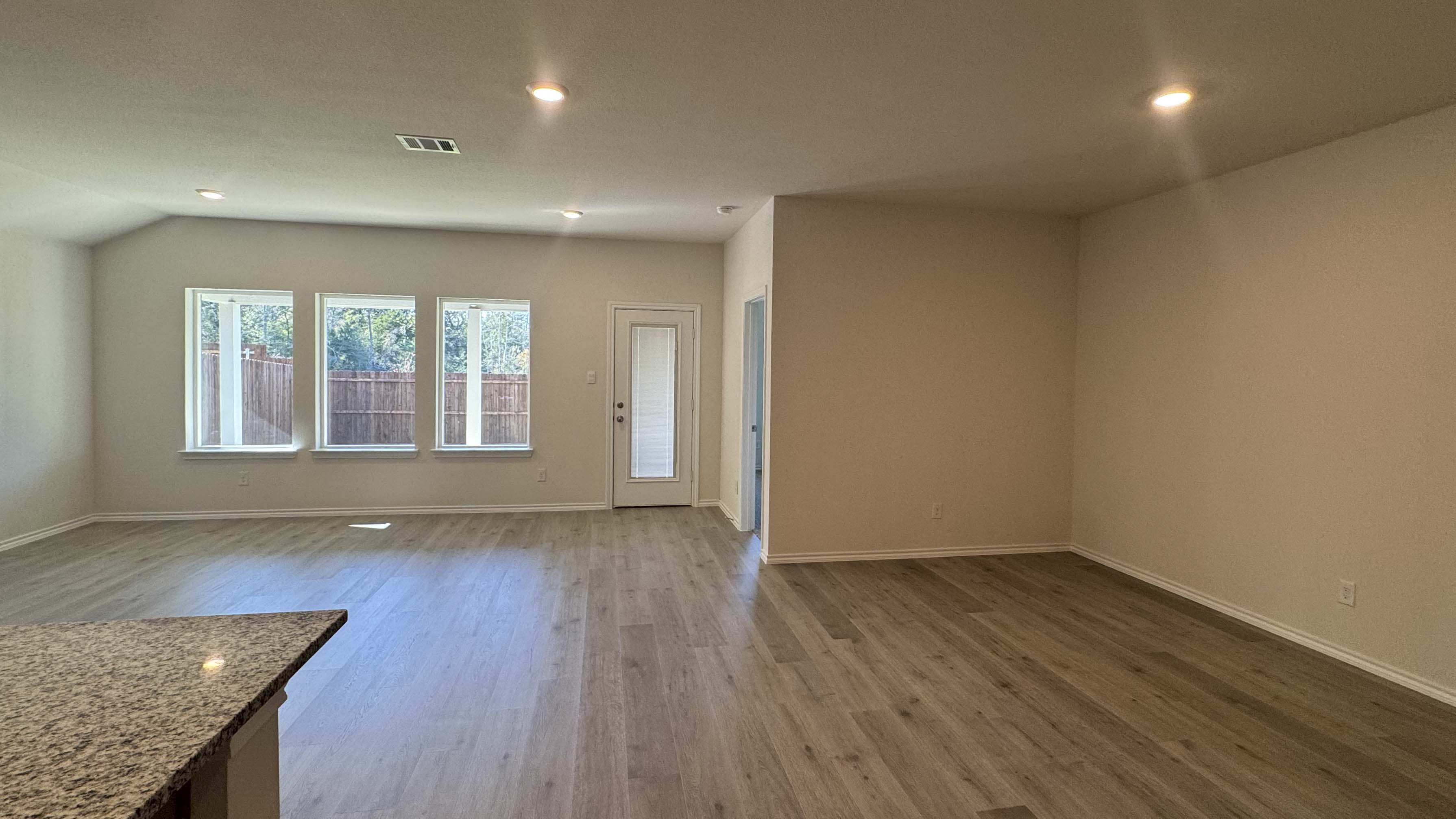 dining and living area with hardwood floors and large windows providing natural light