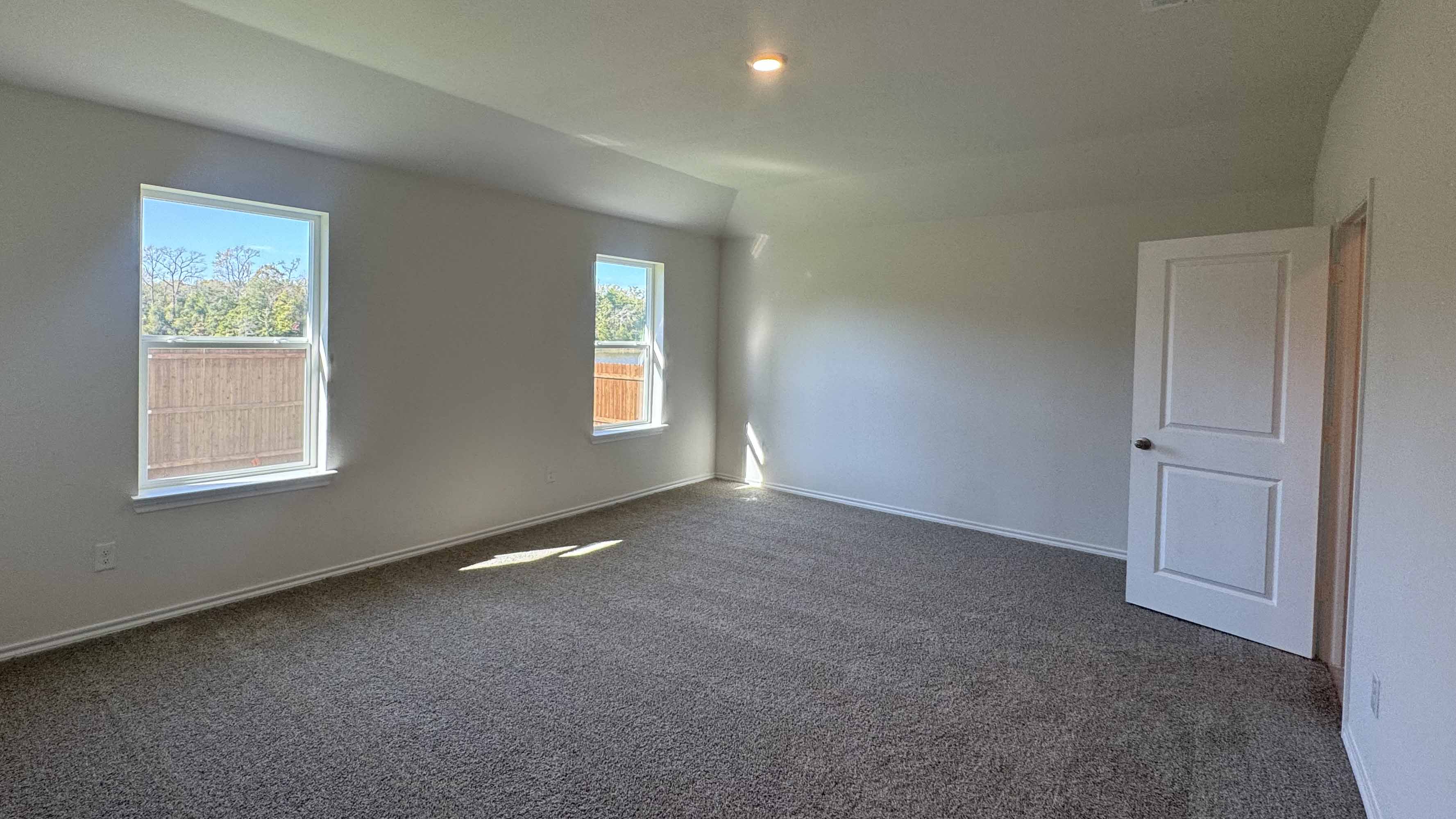 primary bedroom with large windows providing natural light