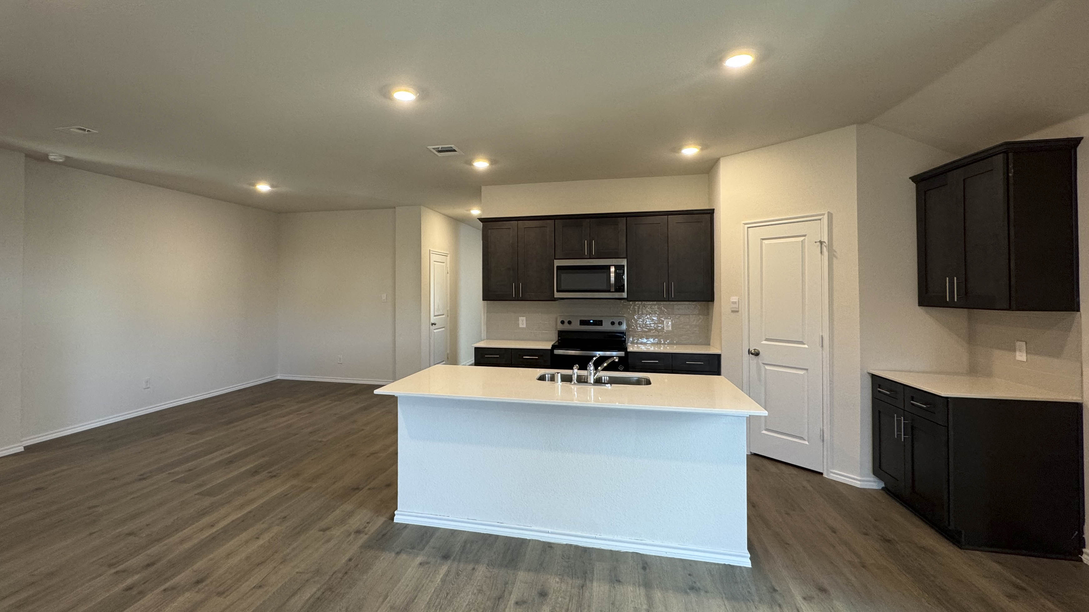kitchen area with dark cabinets and white counters