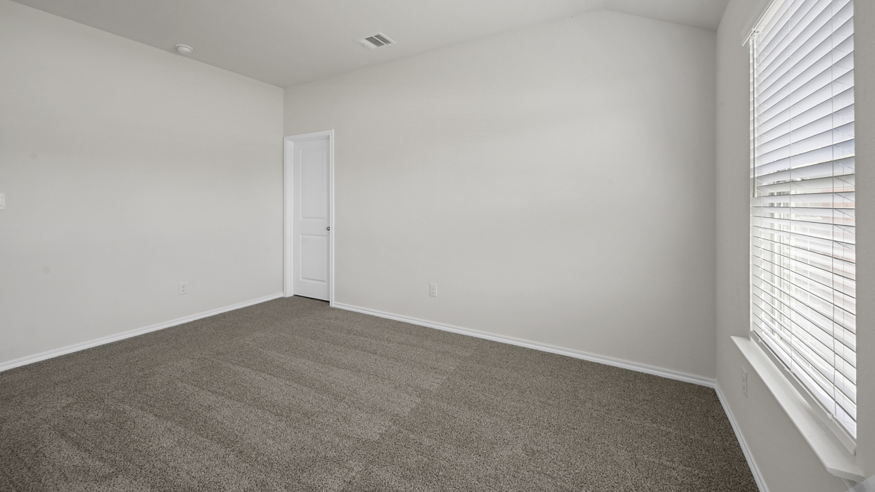 Primary bedroom with light brown carpet