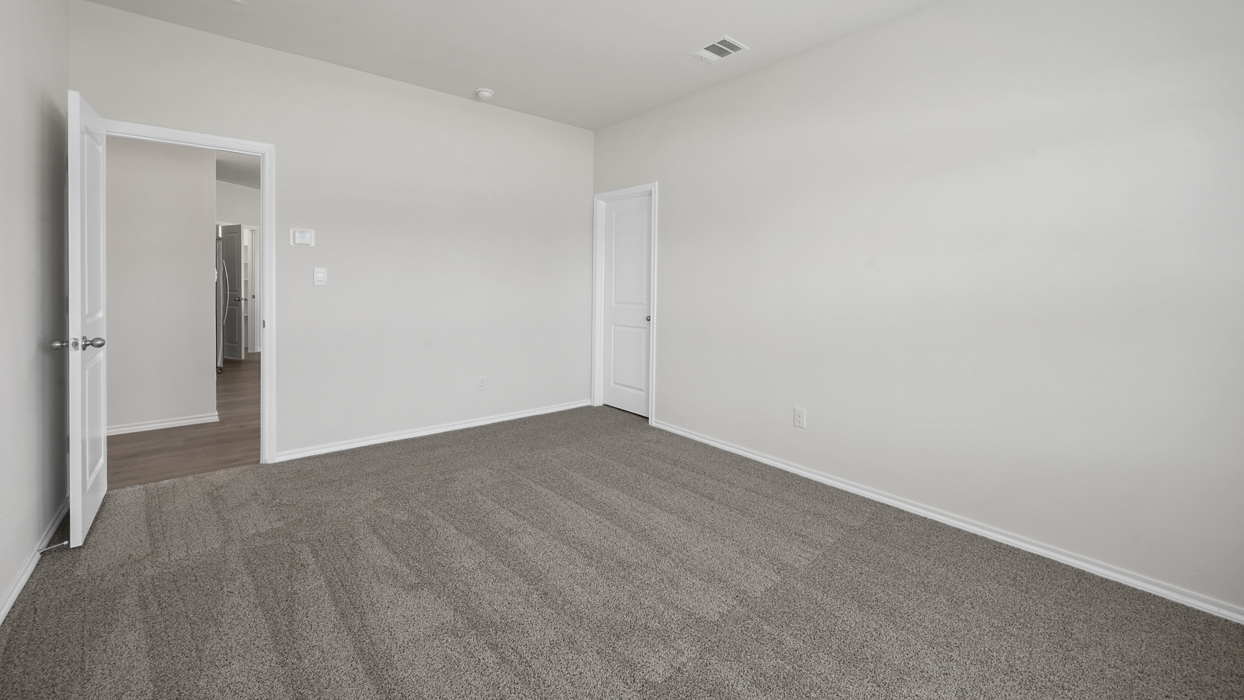 primary bedroom with light brown carpet