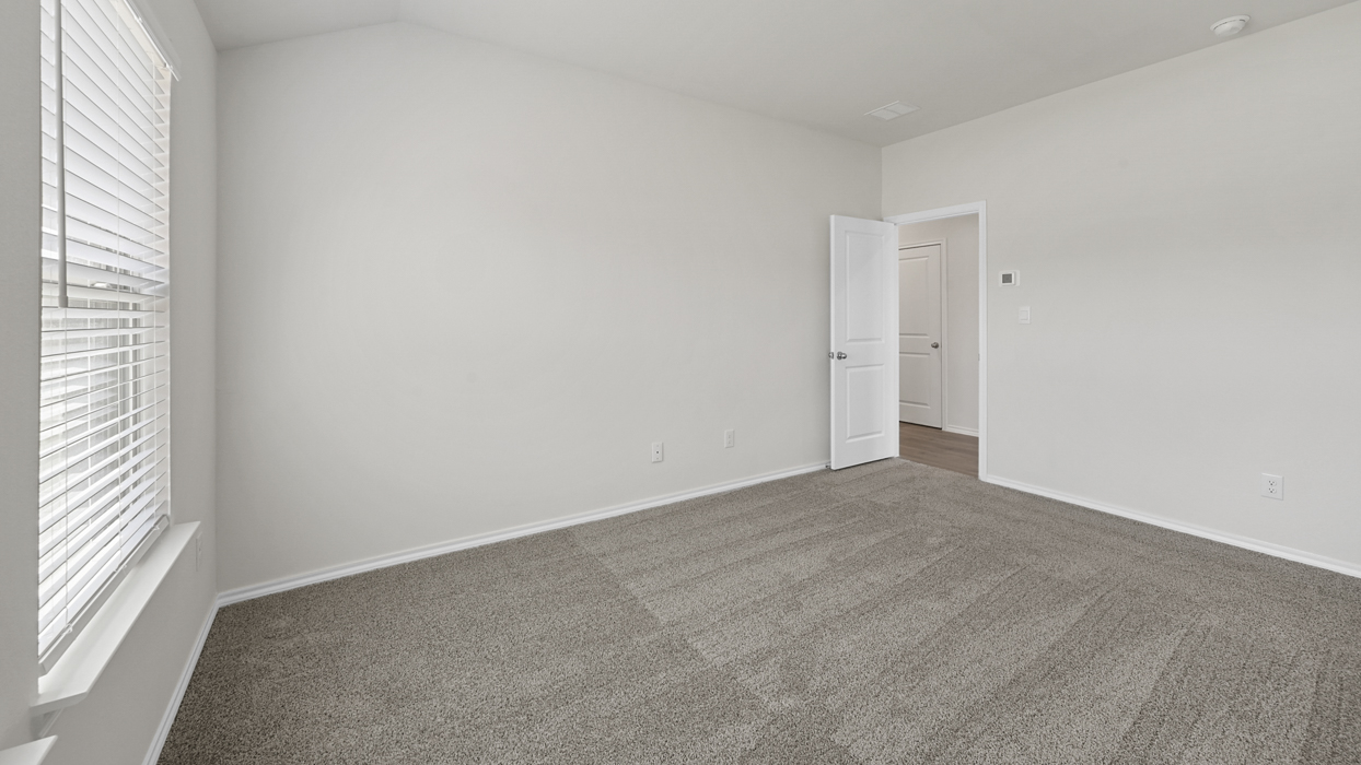 Primary bedroom with light brown carpet