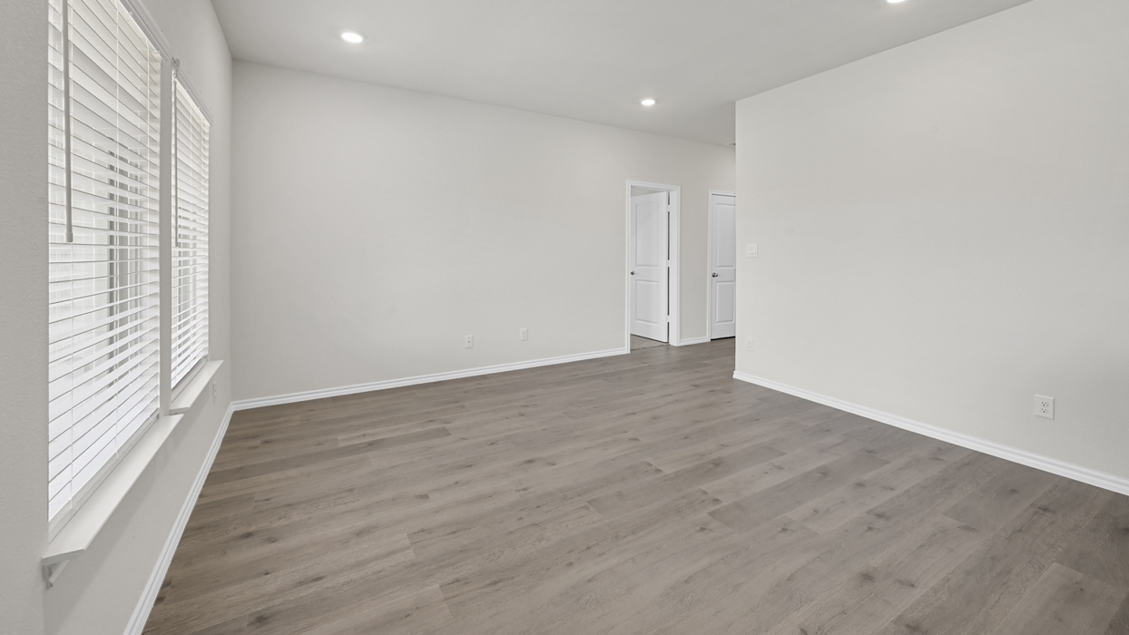 large primary bedroom with windows and ceiling lights
