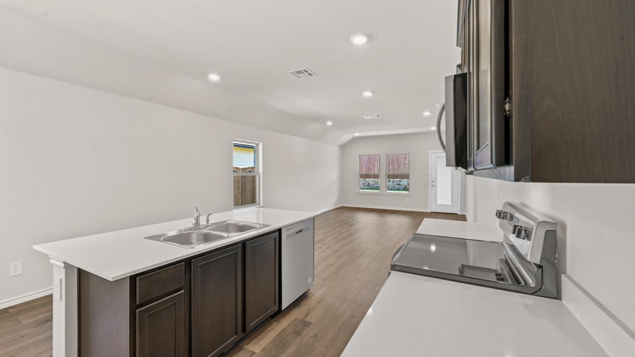 Kitchen area with hardwood floors white counters and dark cabinets with kitchen island