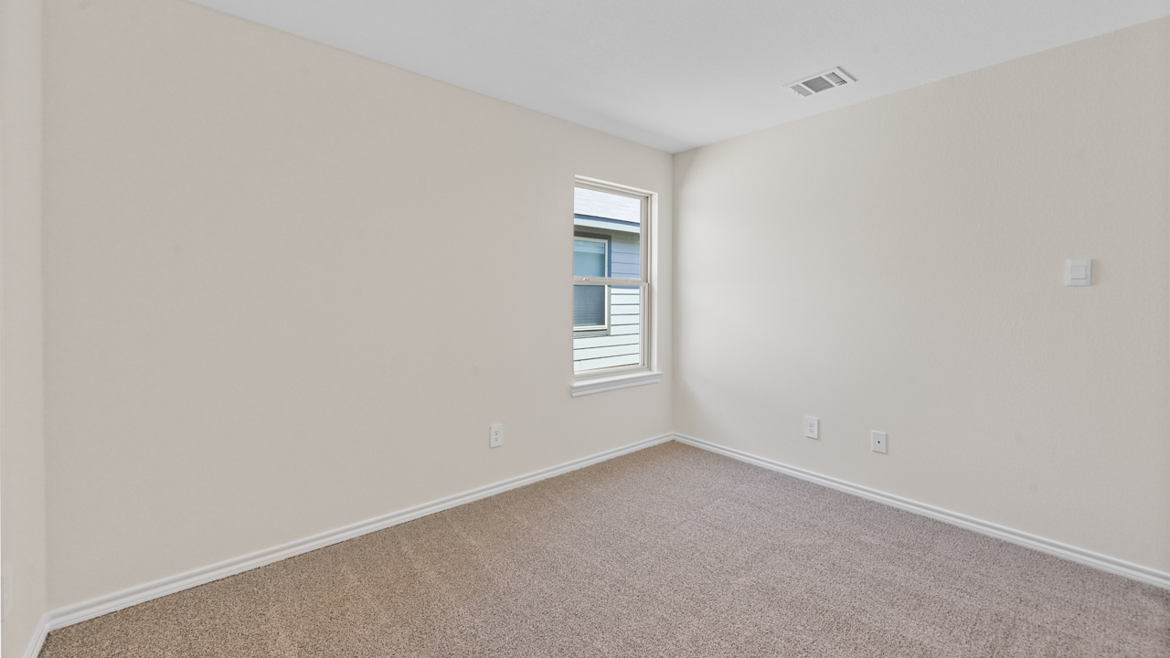Secondary bedroom with carpet and large window providing natural light