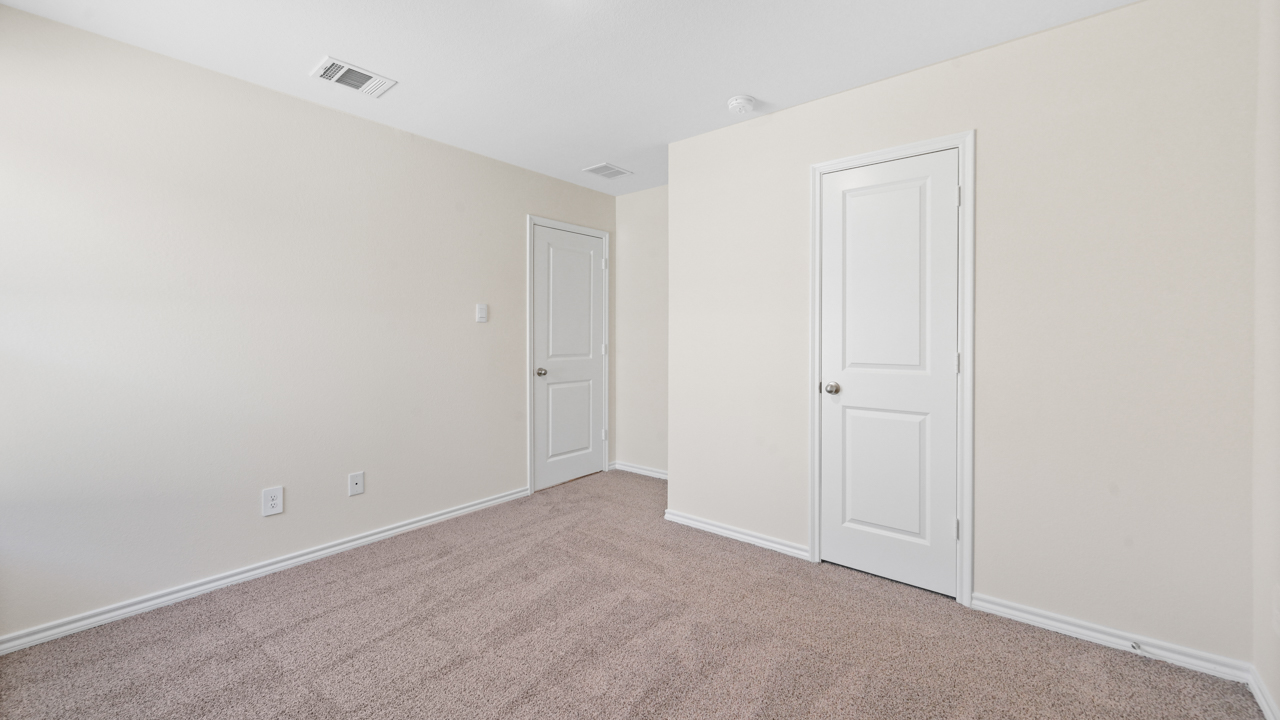 Secondary bedroom with carpet and large window providing natural light