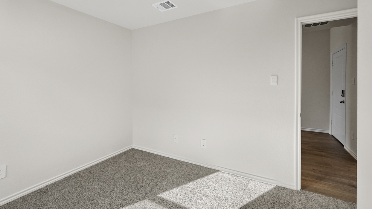 an open bedroom with white walls and gray carpet