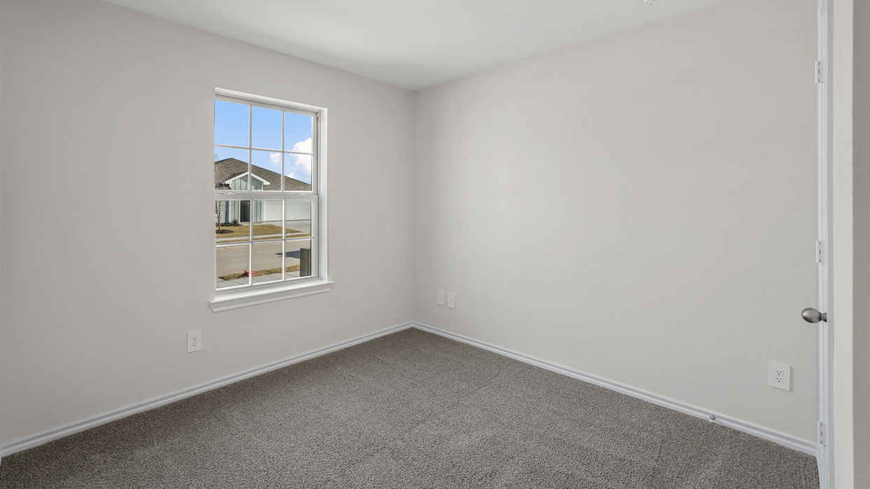 an open bedroom with white walls and gray carpet